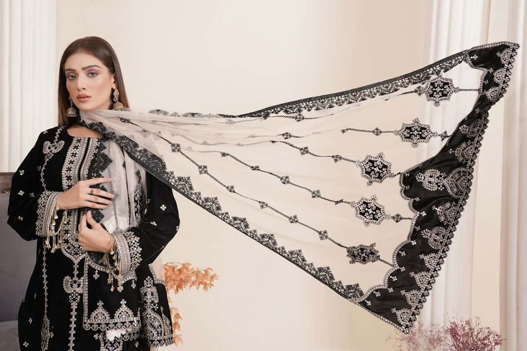 a woman in a black and white outfit holding a black and white shawl