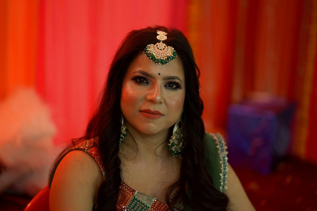 a woman wearing a green and gold head piece