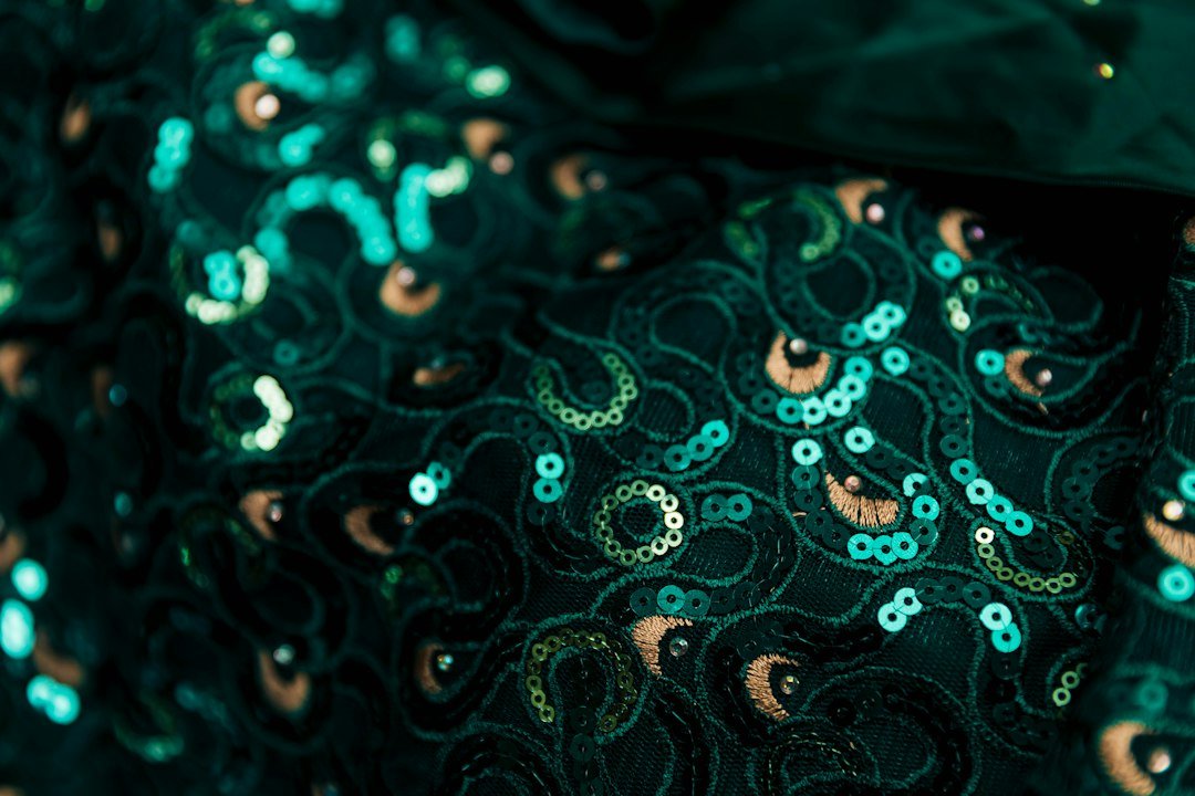 a close up of a green and gold tie