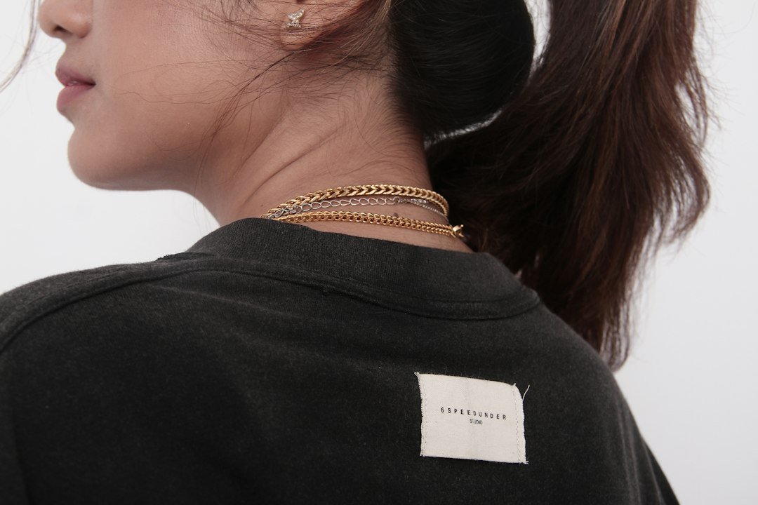 Person from behind wearing a black shirt and gold necklace
